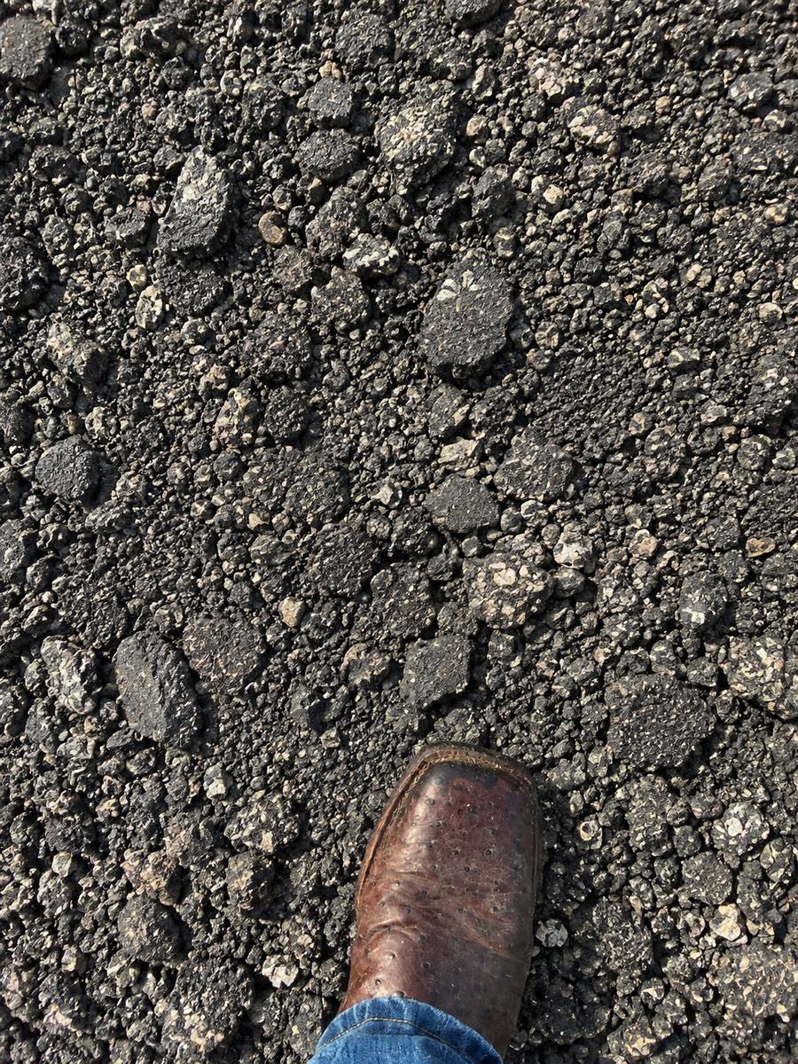 Asphalt millings with a work boot for scale