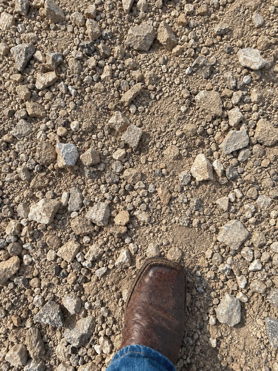 Pit road base material with a work boot for scale