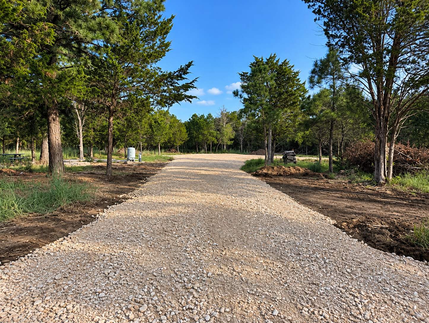 Cleared gravel driveway running through wooded property